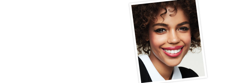 Get the step-by-step application tips for the Feline Flick Look created by Mary Kay Guest Makeup Artist Sam Addington. On right corner, a tilted square shoes a young woman with a big smile on her face wears a winged eyeliner and pink lipstick.